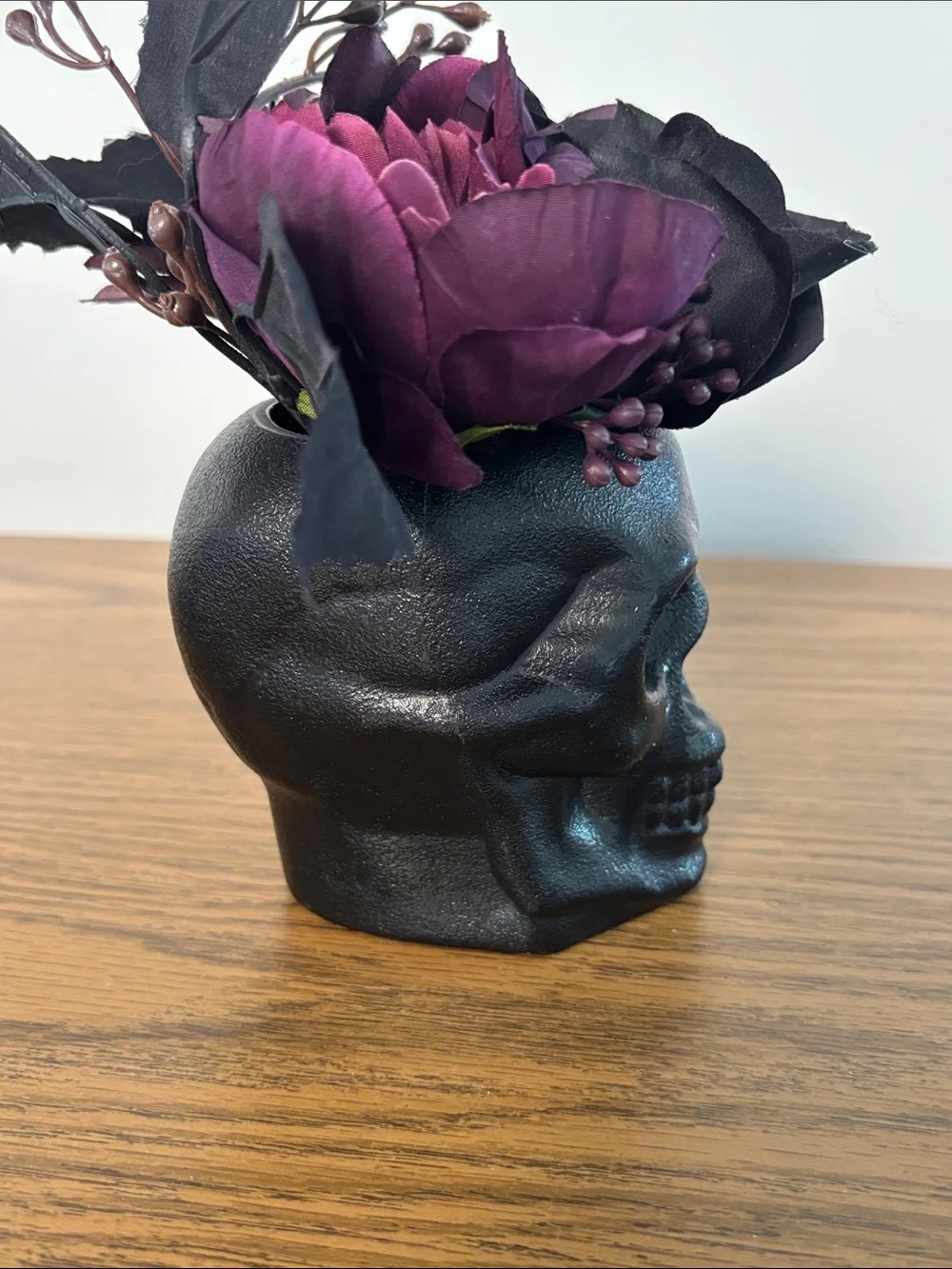 Black Skull Vase with Dark Purple Floral Arrangement